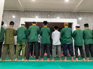 Santri sedang murojaah hafalan Al-Qur’an dengan membacanya dalam shalat, menjaga hafalan sekaligus menambah kekhusyukan ibadah.