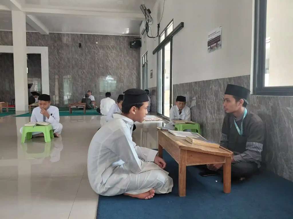 Santri sedang murojaah Al-Qur’an bersama musyrif dengan bacaan tahqiq