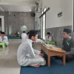 Santri sedang murojaah Al-Qur’an bersama musyrif dengan bacaan tahqiq