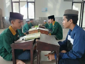 Dua santri saling menyimak dan mengoreksi hafalan Al-Qur’an dengan metode murojaah berpasangan di Ma’had Sabilul Qur’an